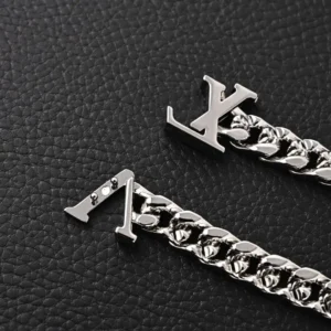 Louis Vuitton bracelet silver-tone metal chain link accessory with LV logo clasp on black textured background