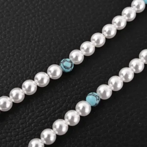 Louis Vuitton LV Turquoise Logo Letter Metal bracelet featuring turquoise beads and pearl accents, set against a textured black background, highlighting luxury fashion design.