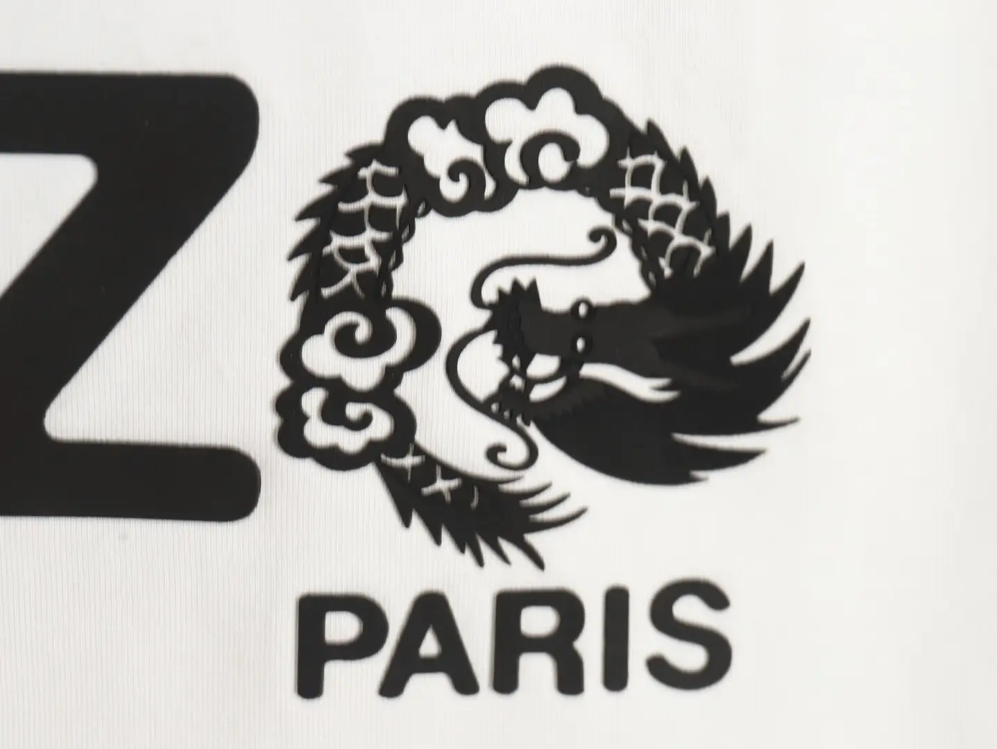 Kenzo logo black dragon emblem on white fabric background
