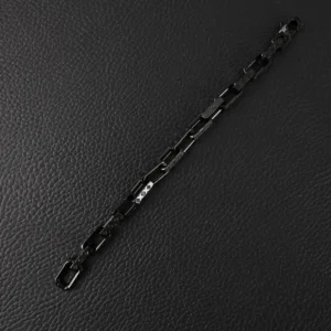 Black quenched bamboo necklace with titanium steel chain link and engraved Louis Vuitton logo, displayed on textured black surface.