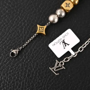 Louis Vuitton LV DamierPar necklace featuring antique gold beads and signature logo tag on textured black background.