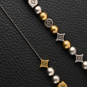 Louis Vuitton LV DamierPar necklace featuring antique gold and silver beads, showcasing brand logos and intricate designs on a textured black background.