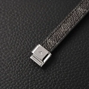 Louis Vuitton Links logo leather buckle bracelet featuring a sleek leather band and metallic clasp on a textured black background.