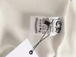 Chrome Hearts hoodie clothing tag with brand logo and care instructions on a white fabric background.