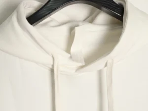 White Chrome Hearts hoodie with drawstring and textured metal hole, showcasing minimalistic design elements.