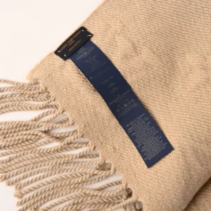 Louis Vuitton 3D Embossed Logo Wool Tassel Long Scarf with label and fringed edges, showcasing premium craftsmanship and luxury accessory appeal.