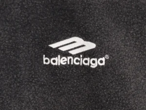 Balenciaga logo on black hoodie fabric, showcasing designer branding for the Balenciaga Reverse Wear collection.