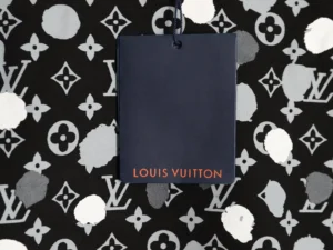 Louis Vuitton tag on polka dot patterned background, showcasing luxury branding for the featured hoodie.