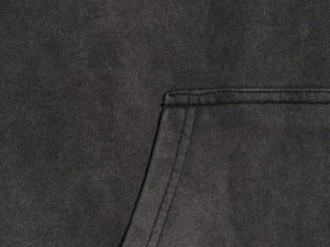 Close-up of a black hoodie fabric featuring a pocket, highlighting the texture and stitching details, relevant to the Balenciaga hoodie product description.