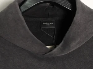 Balenciaga hoodie showcasing the brand label on a dark fabric background, emphasizing luxury fashion replica quality and design details.