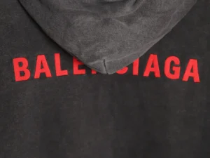 Balenciaga hoodie featuring bold red lettering on a black fabric background, highlighting the luxury replica design and craftsmanship.