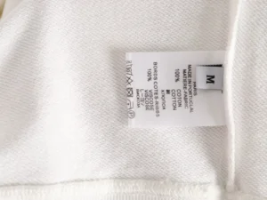 No brand or product type visible on this white clothing fabric label showing material composition of 100% cotton and viscose ribs