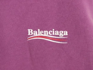 Balenciaga logo on a purple hoodie, showcasing designer branding for the Classic Cola Seal sweatshirt.