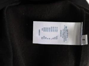 Label tag on a black Louis Vuitton hoodie displaying size options and care instructions, relevant to the product listing on an e-commerce site.