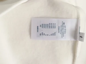 Louis Vuitton clothing size tag white fabric with size chart and product codes in black text
