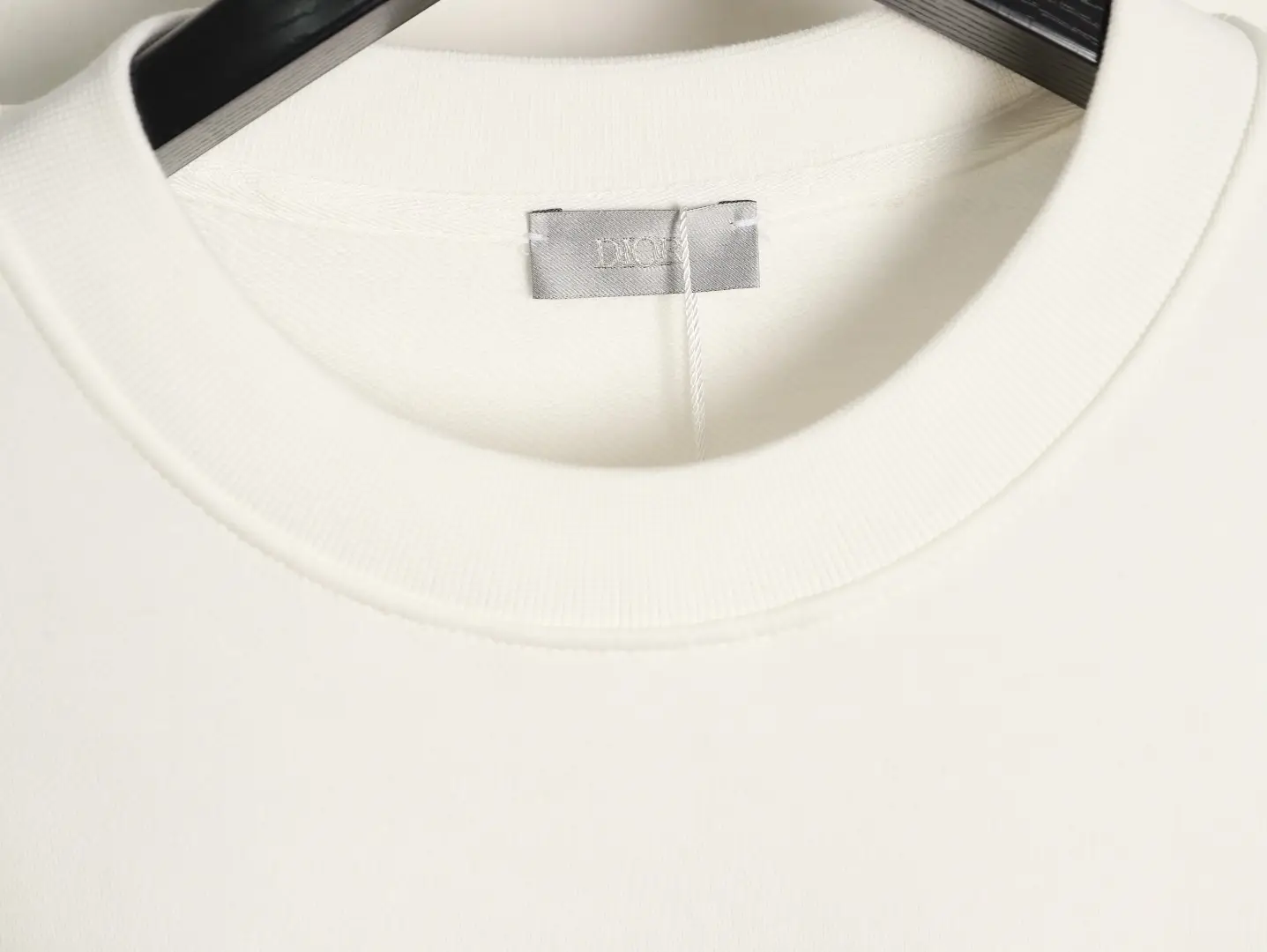 DIOR 47 letter round neck guard detail showcasing soft fabric and brand label, emphasizing luxury and comfort for stylish casual wear.