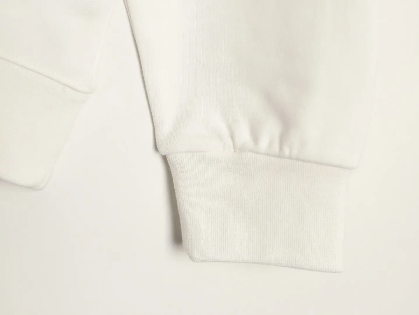 White cuff detail of a DIOR 47 letter round neck guard hoodie, showcasing comfortable fabric and stylish design.