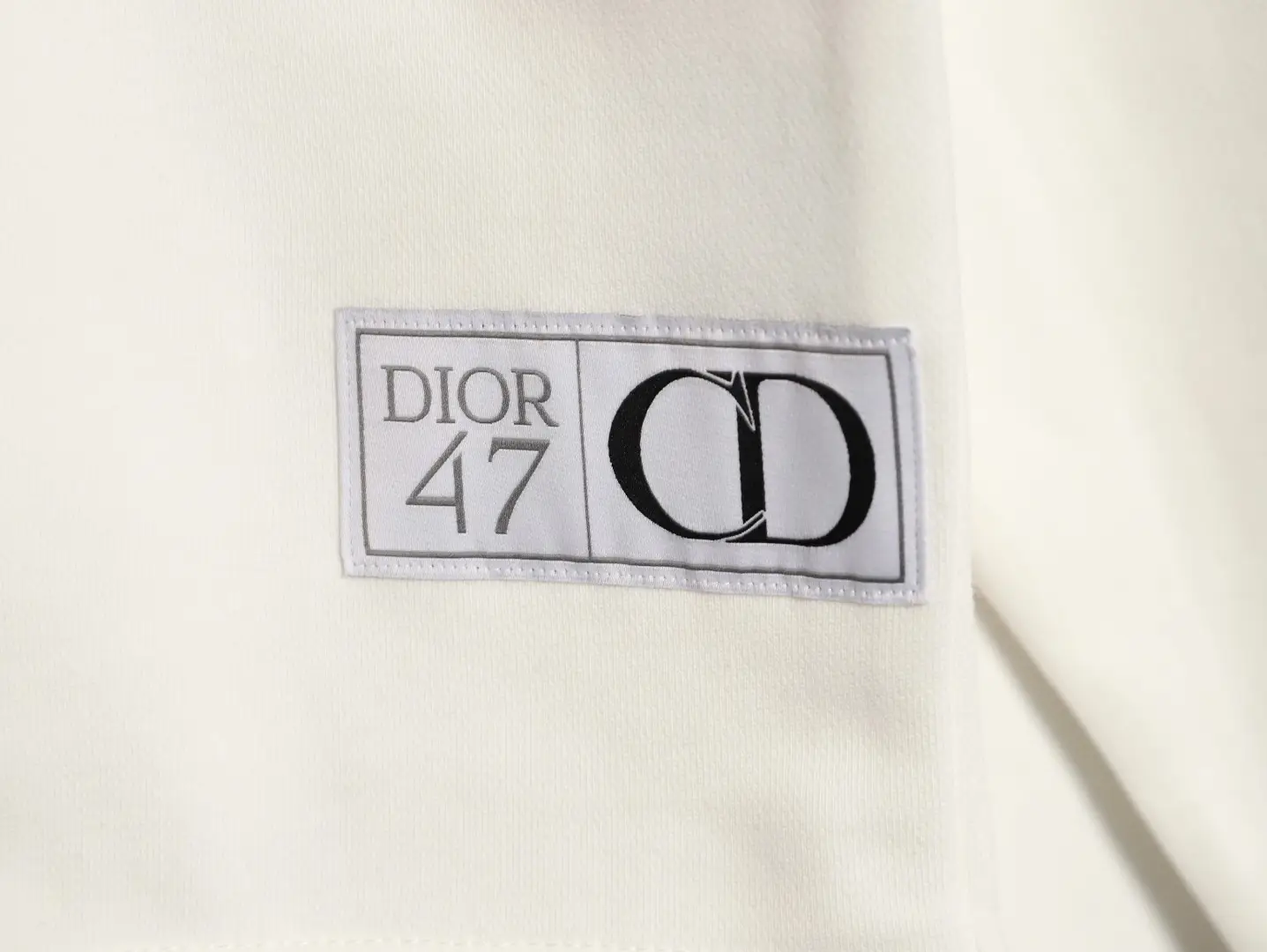 DIOR 47 label on round neck guard, featuring elegant design and branding, emphasizing luxury fashion for men and women.