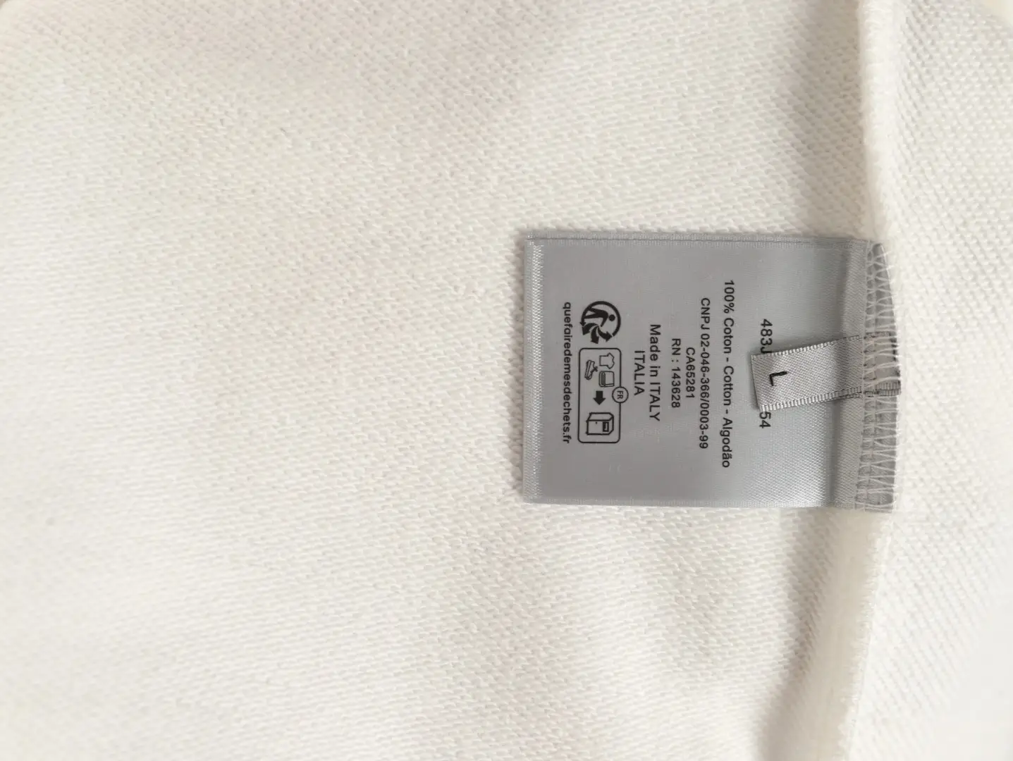 Label tag on a DIOR 47 letter round neck guard, featuring fabric composition details, size, and care instructions, emphasizing luxury and quality for clothing.