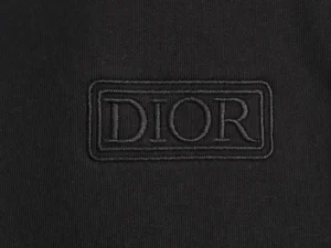 DIOR logo embroidered on a black sweatshirt fabric, highlighting luxury fashion design.