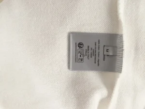 Label tag on a DIOR letter embroidered round neck sweatshirt, displaying care instructions and size information.