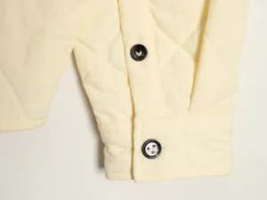 Ivy Park Quilted Jacket Sleeve Cream cotton fabric with black buttons close-up