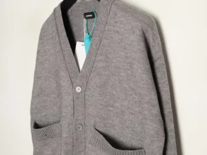 Gray cardigan sweater with a v-neck, buttons, and front pockets, displayed on a hanger, representing a stylish winter clothing option.