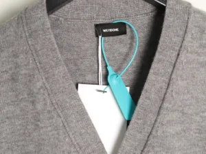 WE11 DONE Winter New White jacket featuring a minimalist design, gray fabric, and brand tag, emphasizing luxury and warmth for autumn and winter.