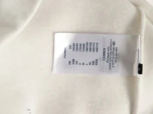Label tag displaying size and care instructions for a Louis Vuitton hot air balloon hoodie replica, emphasizing fabric quality and sizing options.