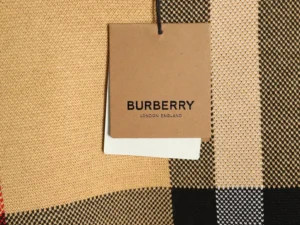 Burberry tag on plaid patchwork fabric showcasing designer quality and craftsmanship.