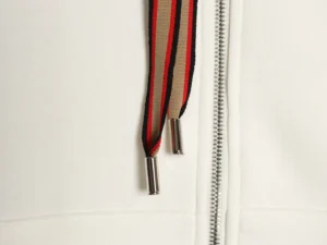 Burberry hoodie zipper detail featuring striped drawstrings and metal tips, showcasing high-quality craftsmanship and design elements.