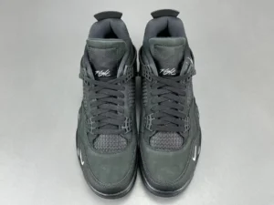 Jordan 4 RM SP Nigel Sylvester Driveway Grey sneakers, featuring a sleek black design with textured materials and signature branding, presented on a neutral background.