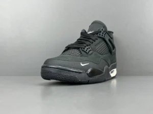Jordan 4 RM SP Nigel Sylvester Driveway Grey sneaker featuring a sleek black design, prominent Nike logo, and textured upper, showcased against a neutral background.
