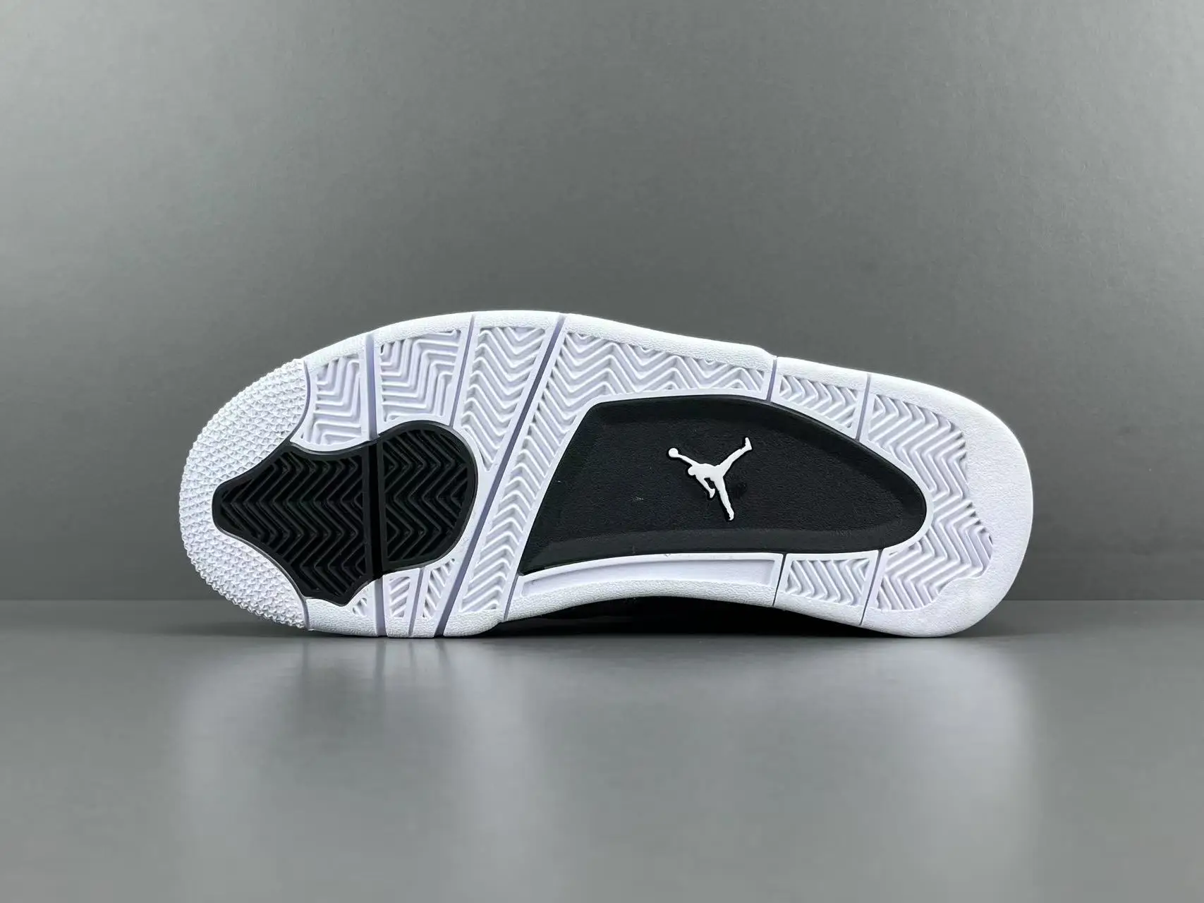 Nike Air Jordan 4 Retro black white rubber sole sneakers with Jumpman logo outsole traction pattern