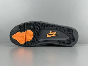 Nike Air Jordan 4 sneaker sole featuring black rubber with orange accents and iconic Nike logo, highlighting the UNDEFEATED collaboration.