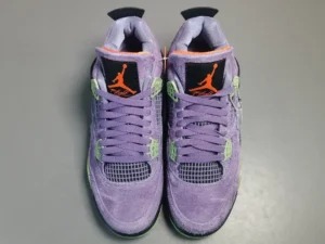 Air Jordan 4 Retro Canyon Purple sneakers featuring a vibrant purple suede upper, black accents, and neon green details, displayed from a top-down view.