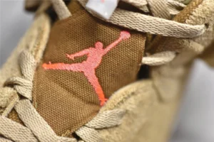 Air Jordan 6 Retro Travis Scott British Khaki sneaker detail featuring iconic Jumpman logo in pink against brown suede material.