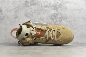 Air Jordan 6 Retro Travis Scott British Khaki sneaker featuring a tan suede upper, white laces, and signature branding, displayed on a gray surface.