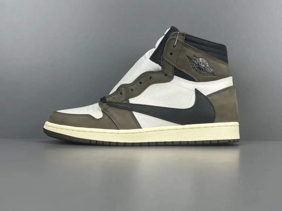 Travis Scott x Air Jordan 1 High OG sneaker in brown and white with black accents, showcasing a stylish design and the iconic Air Jordan logo.