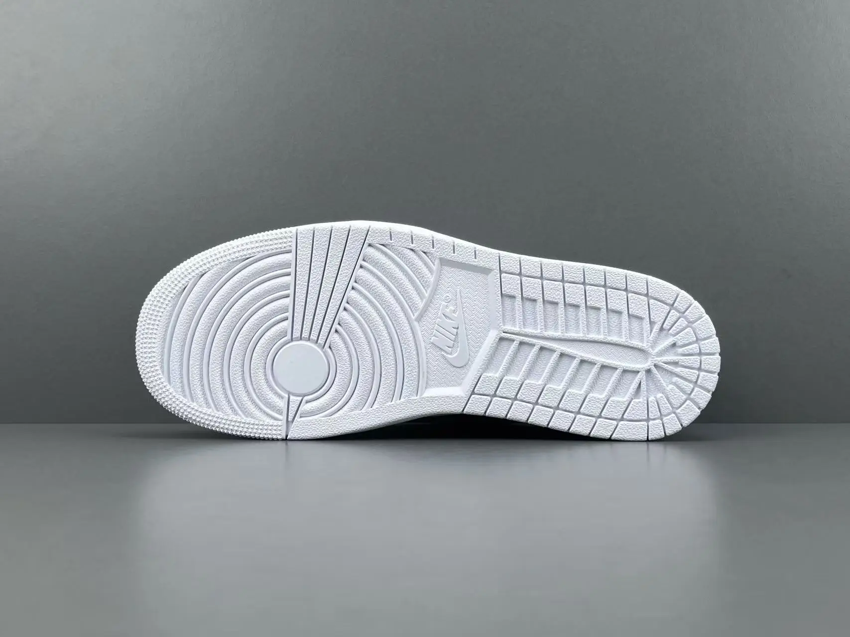 Nike Air Jordan 1 Low white outsole rubber sneakers with circular traction pattern and Nike logo embossing