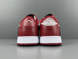Travis Scott x Air Jordan 1 Low OG shoes featuring red leather upper, black accents, and iconic Air Jordan branding on the heel.
