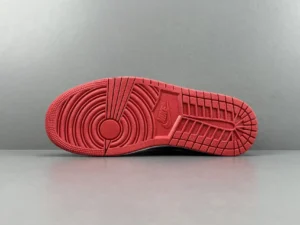 Red outsole of Travis Scott x Air Jordan 1 Low OG sneaker, showcasing detailed tread pattern and Nike logo.
