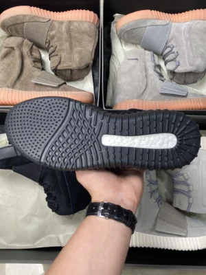 Adidas Yeezy 750 Boost black suede sneakers with gum sole and white Boost cushioning visible on outsole