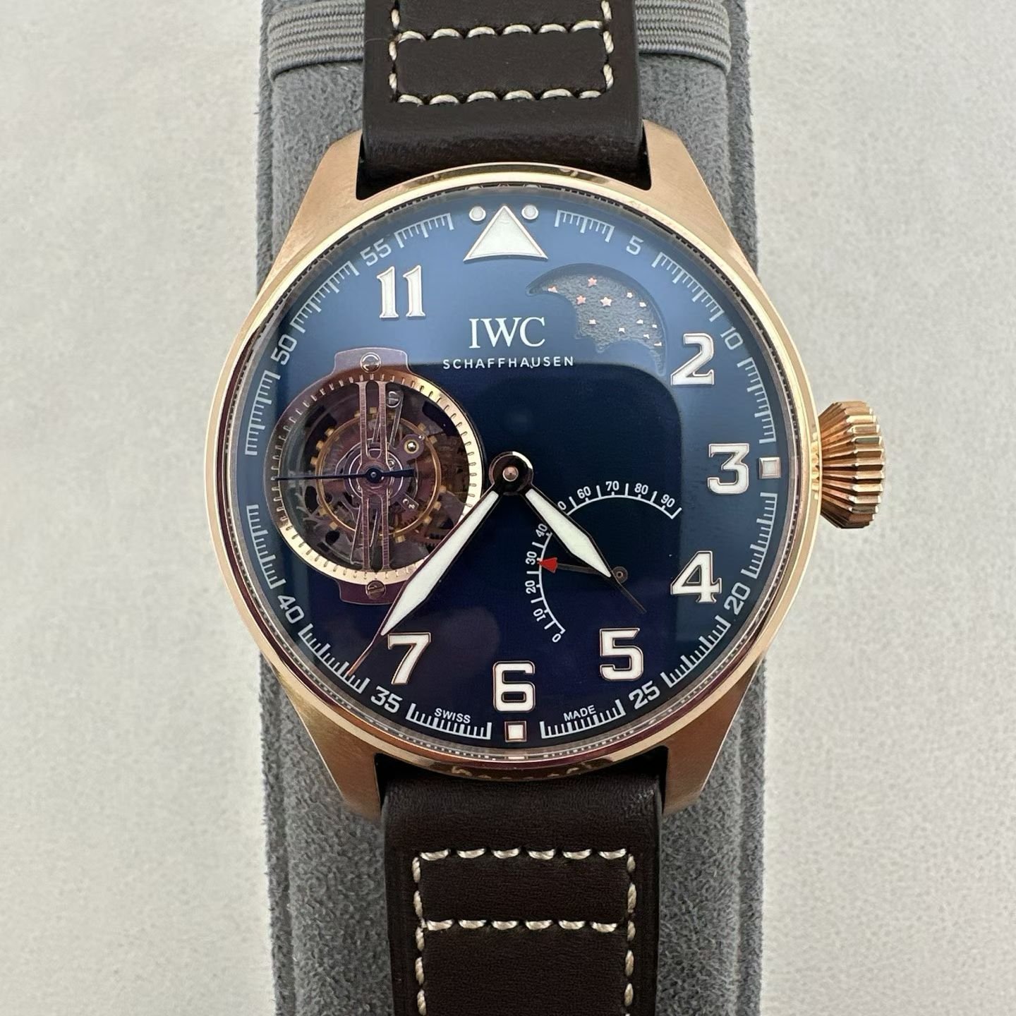 The IWC Large Pilot Constant Power Tourbillon "Little Prince" IW590303, with a 46.5mm bronze case and a deep radiating blue disc. The left hollowed out constant power tourbillon window is equipped with a star moon moon phase display and curved power reserve indicator on the dial, a classic pilot sized Arabic hour marker, and a vintage brown stitched cowhide strap. Equipped with Cal.94805 manual winding self-made movement, 341 parts, 41 gems, 45 hours of ultra long power reserve, constant power device matched with tourbillon, weakening the influence of spring torque changes on timekeeping, a high-end watchmaking art collection.